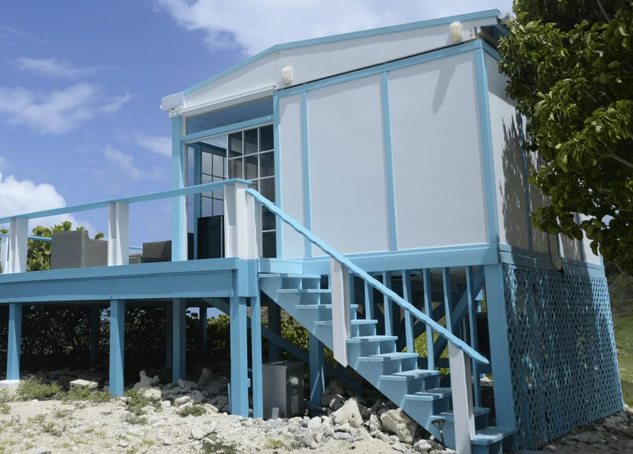 Raised deck on posts with a painted guard rail and open stairs